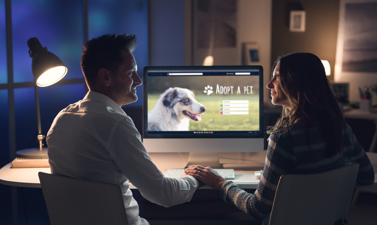 Casal com computador e cachorro