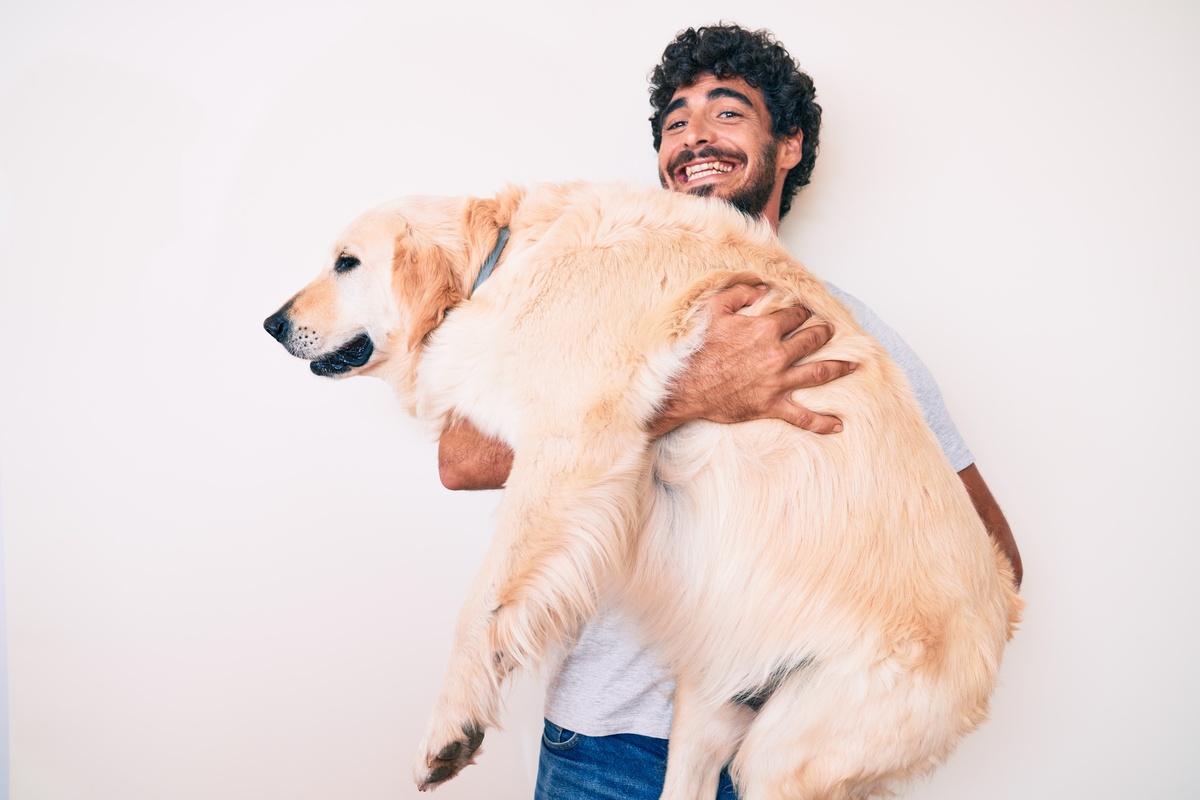 Homem carregando cão grande