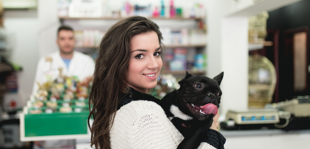 Mulher segurando cachorro em pet shop